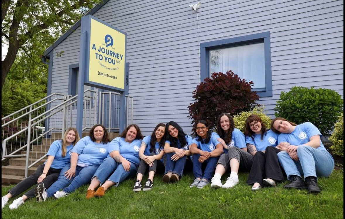 A Journey To You Team sitting outside in grass